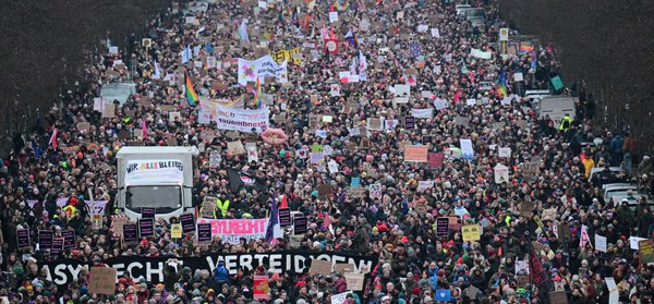 Teilnehmer gehen während einer Demonstration am 2.2.2025 in Berlin unter dem Motto «Aufstand der Anständigen - Demo für die Brandmauer» auf der Straße des 17. Juni - zwischen ihnen ein Transparent mit dem Aufdruck «Asylrecht verteidigen». Der Bundestag hatte einige Tage zuvor mit Unterstützung der AfD einem Antrag der Union zugestimmt, der Zurückweisungen von Asylsuchenden.
