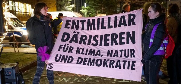 Protest im Januar 2025 gegen ein exklusives Lobby-Event des Axel­-Springer Verlags in Berlin. Transpi mit der Aufschrift: "Entmilliardärisieren. Für Klima, Natur und Demokratie."